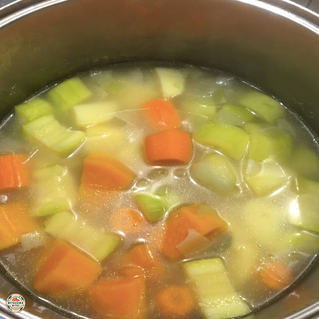 Vegetable soup simmering in a pot while the vegetables cook until soft