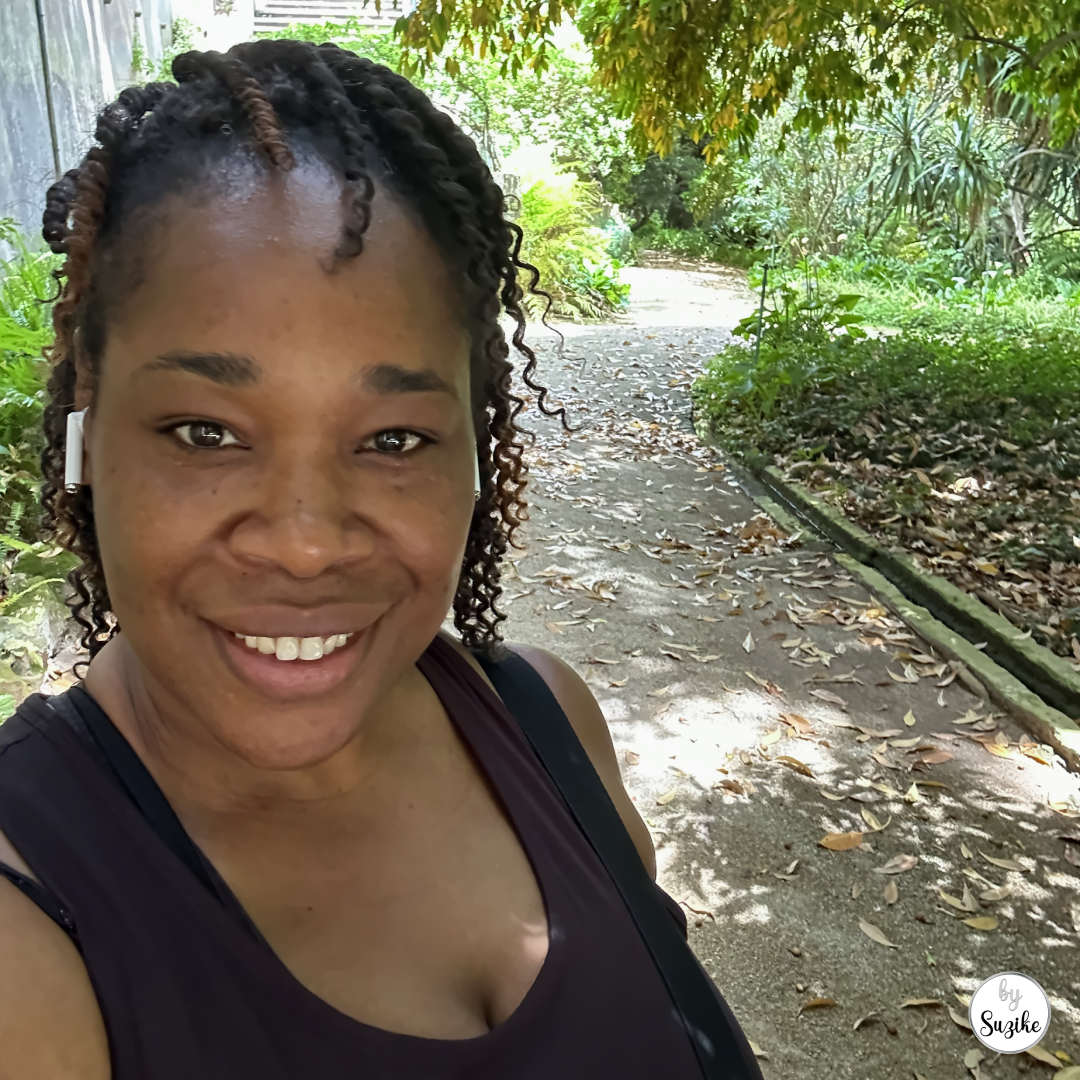 Woman smiling during an outdoor walk on a shaded path for the post how much walking for weight loss