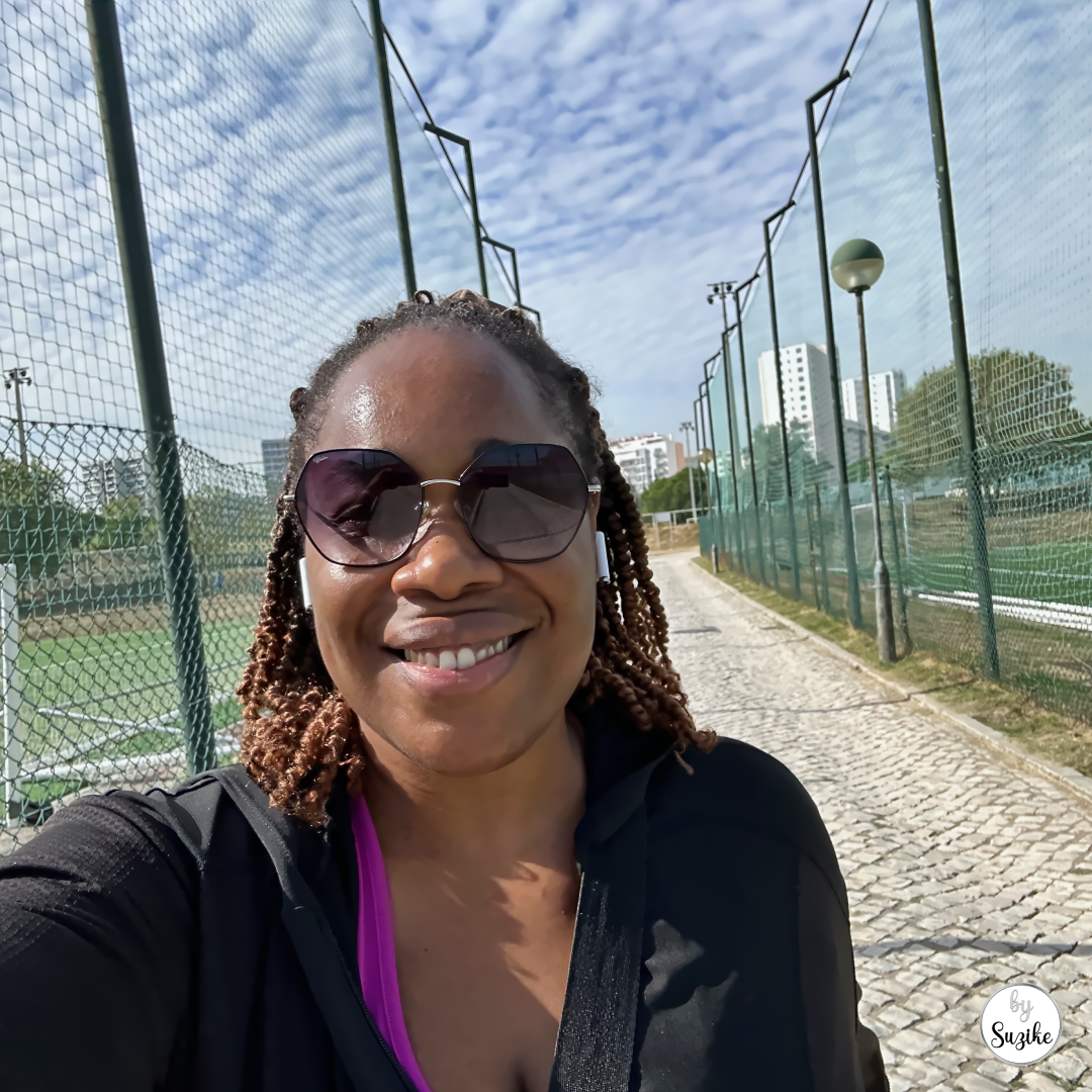 Woman smiling during an outdoor walk near a sports court for a walking for weight loss post