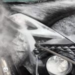 Car covered in foam during the main wash at a self-service car wash in Portugal
